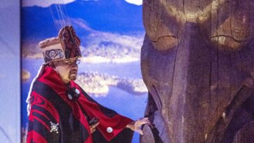 Sim'oogit Ni'isjoohl (Mr. Earl Stephens) of Nisga'a Nation with the Ni'isjoohl memorial pole.