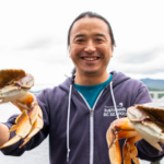 Restaurant owner and chef Dai Fukasaku holding two Dungeness Crabs.