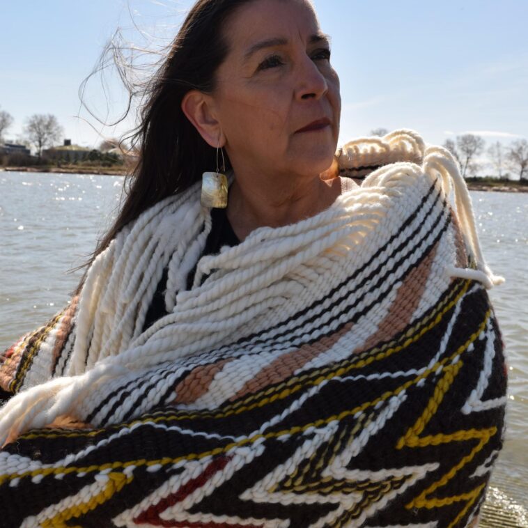 A woman wearing a Coast Salish blanket.