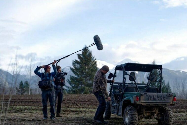 A man holding a mic boom over a filming scene from the documentary, "Tea Creek".