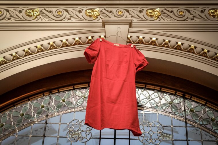 A red dress hung over an arch at a government building