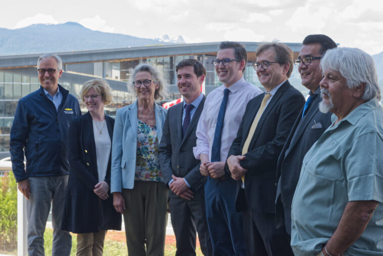 Representatives from the BC government and Federal government with BC-based spokespersons pose for a photo at the government's announcement of BC's fish farm transition transition plan.