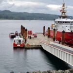 A red Canadian Coast Guard vessel reloading at a dock