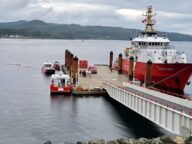 A red Canadian Coast Guard vessel reloading at a dock