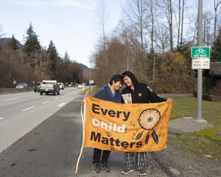 Kimberly (left) and Jordan Joseph on Highway 99, Sḵwx̱wú7mesh (Squamish). The couple planned a walk from “Prince Rupert” to “Victoria” raising awareness for indigenous children in foster care